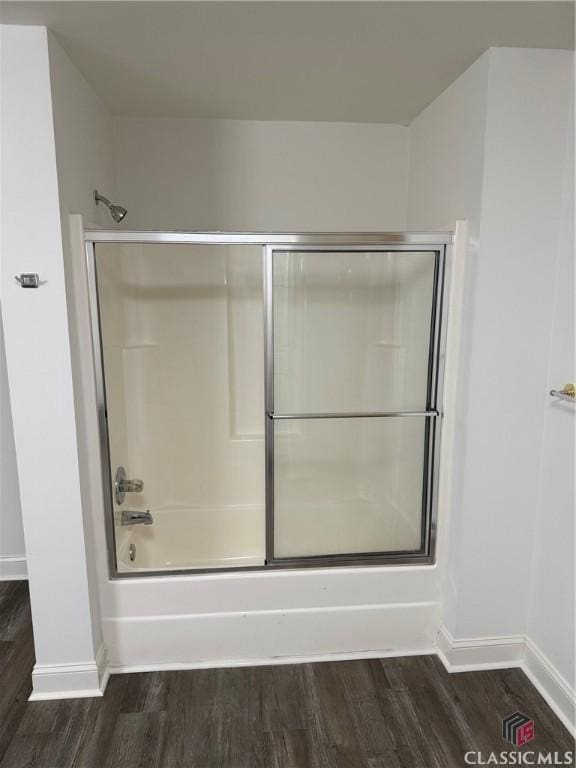 bathroom with shower / bath combination with glass door and wood-type flooring