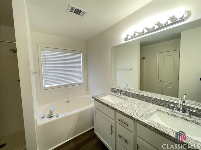 bathroom featuring hardwood / wood-style floors, vanity, and a tub