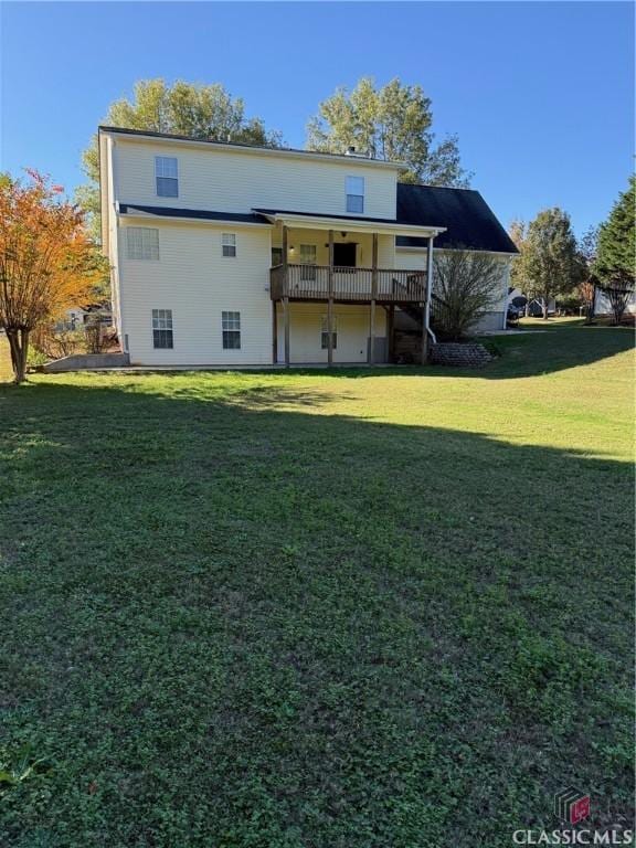 back of house with a lawn and a deck