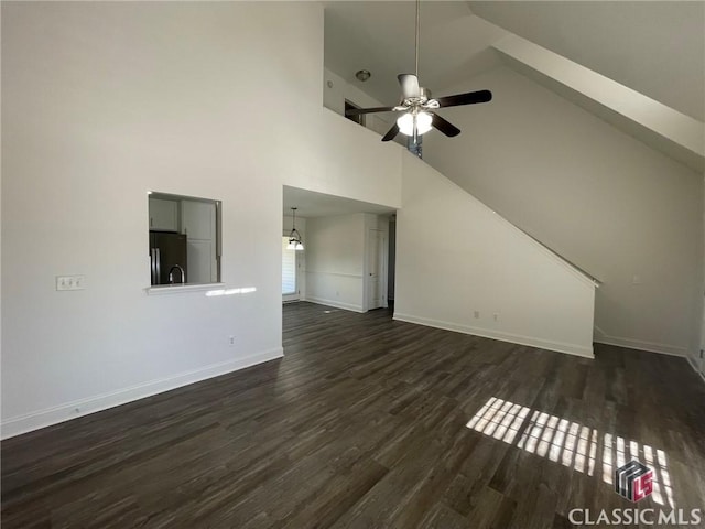 unfurnished living room with high vaulted ceiling, ceiling fan, and dark wood-type flooring