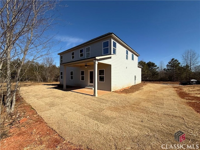 back of property with ceiling fan and a patio area