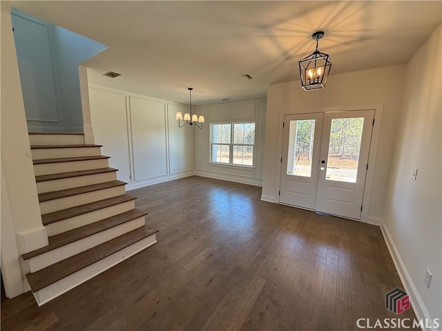 foyer with dark hardwood / wood-style flooring, french doors, and a chandelier