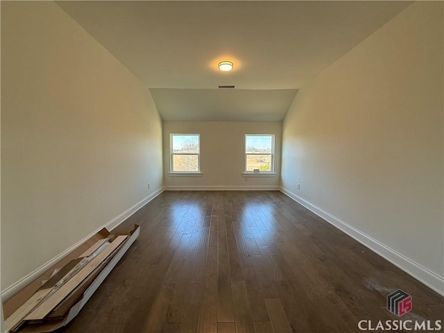 unfurnished room with lofted ceiling and dark hardwood / wood-style flooring