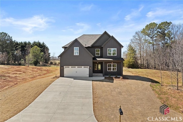 view of front of property featuring board and batten siding, driveway, and a garage