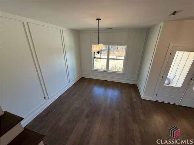 unfurnished dining area with dark wood-type flooring