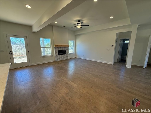 unfurnished living room with dark hardwood / wood-style flooring and ceiling fan