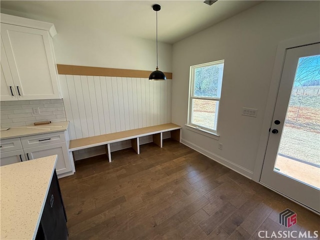 unfurnished dining area with dark wood-type flooring