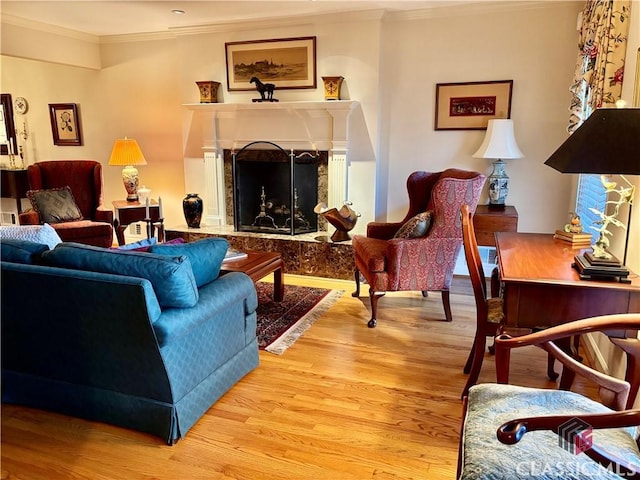 living room with a high end fireplace, wood-type flooring, and crown molding