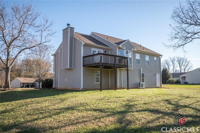 rear view of property featuring a yard and a wooden deck