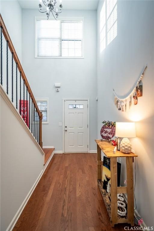 foyer entrance featuring wood-type flooring and an inviting chandelier