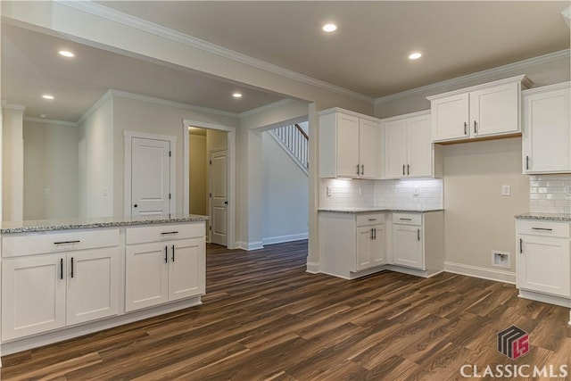 kitchen with white cabinetry, light stone countertops, dark wood-type flooring, and decorative backsplash