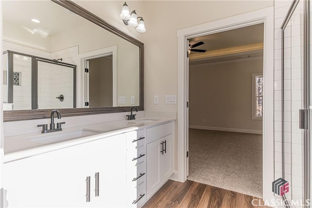 bathroom with hardwood / wood-style flooring, vanity, and a shower with shower door