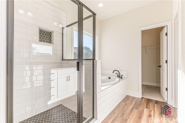 bathroom with hardwood / wood-style flooring and shower with separate bathtub