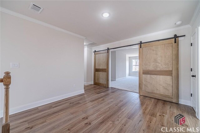 hall with crown molding, a barn door, and dark wood-type flooring