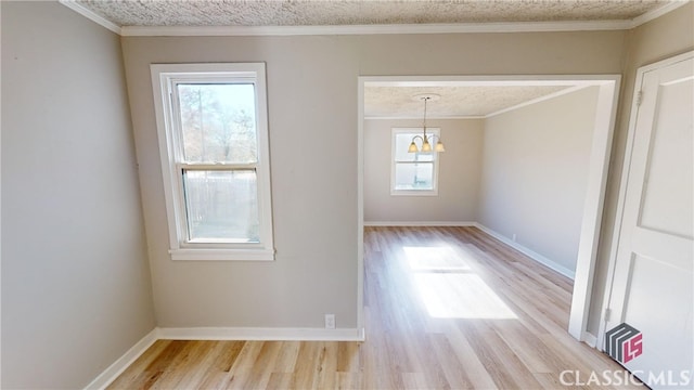 unfurnished dining area featuring a textured ceiling, crown molding, and light hardwood / wood-style flooring