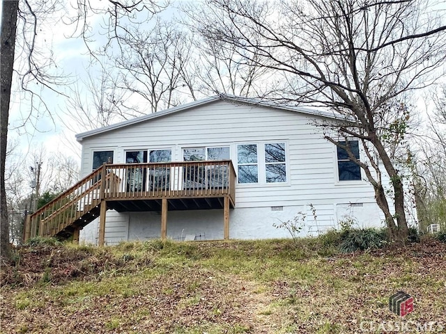 rear view of property featuring a wooden deck