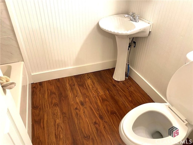 bathroom with a tub to relax in and hardwood / wood-style floors