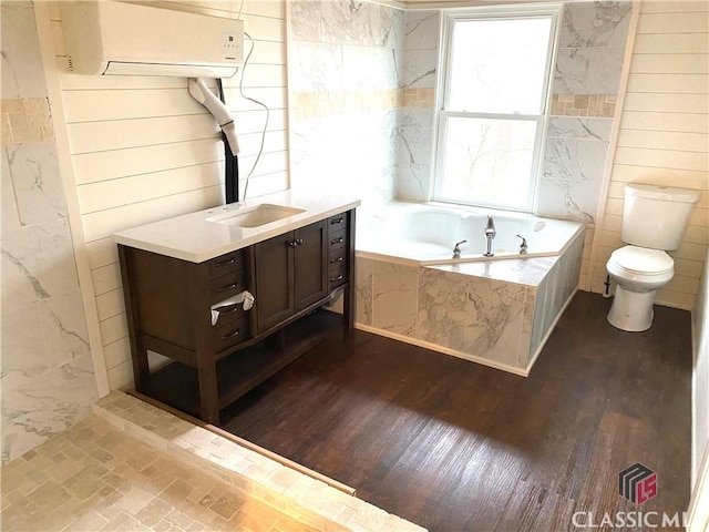 bathroom with toilet, tiled tub, vanity, and hardwood / wood-style floors