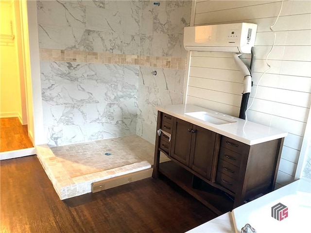 bathroom with hardwood / wood-style flooring, a shower, and vanity