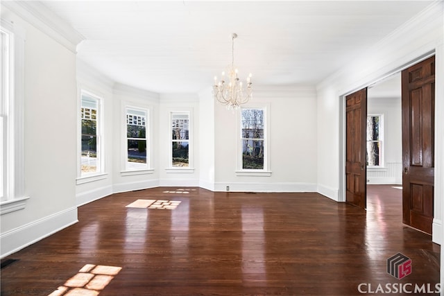 unfurnished dining area featuring baseboards, wood finished floors, a notable chandelier, and ornamental molding