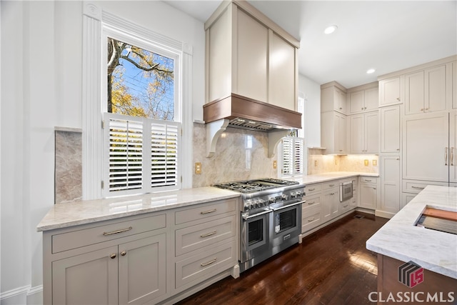 kitchen featuring light stone counters, tasteful backsplash, appliances with stainless steel finishes, and dark wood-style flooring