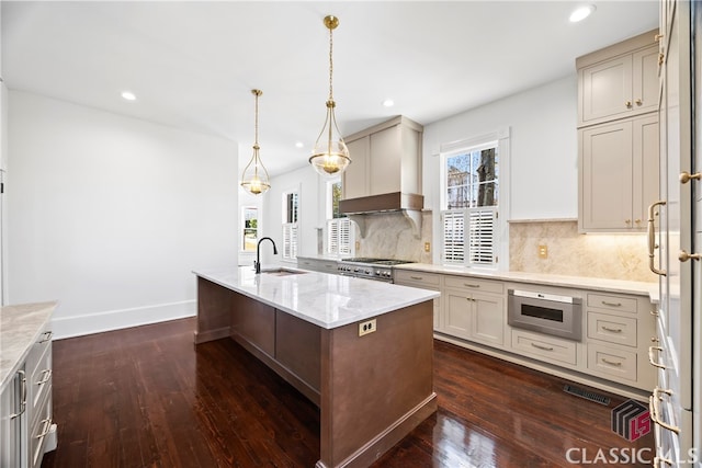 kitchen with a sink, built in microwave, stainless steel range, wall chimney exhaust hood, and dark wood-style floors