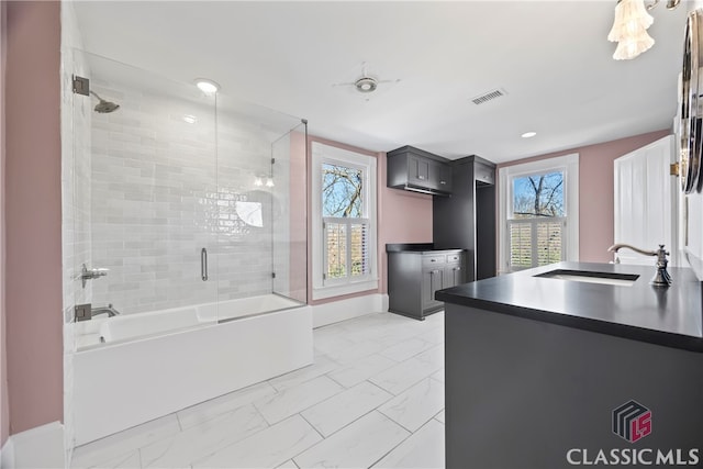 bathroom featuring marble finish floor, combined bath / shower with glass door, visible vents, vanity, and baseboards
