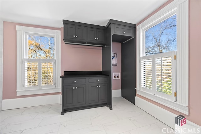 interior space featuring marble finish floor and baseboards