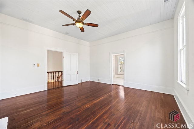 unfurnished room featuring baseboards, a ceiling fan, wood finished floors, and a wealth of natural light