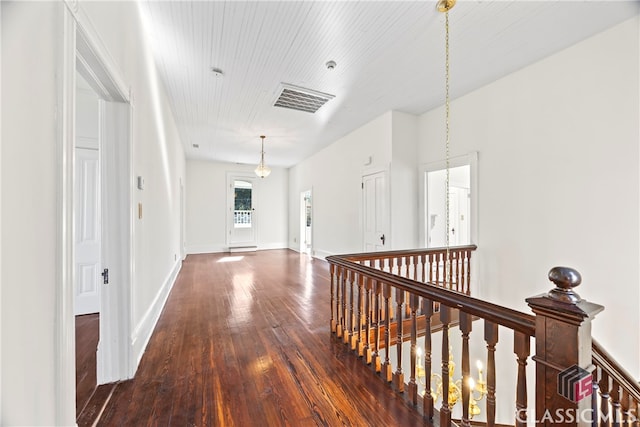 corridor featuring baseboards, visible vents, an upstairs landing, and dark wood-style floors