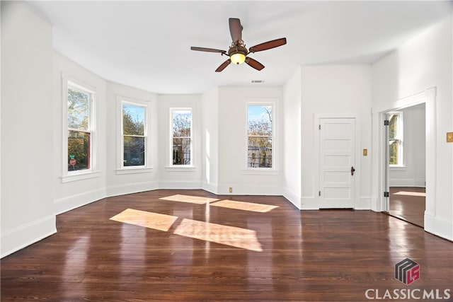 interior space with wood finished floors, visible vents, a ceiling fan, and baseboards