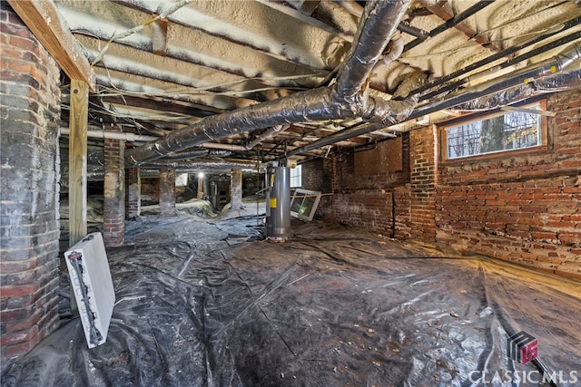 basement with brick wall and water heater