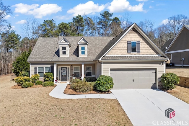 view of front of home featuring a garage, a front lawn, driveway, and a shingled roof