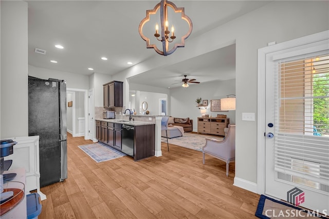 kitchen featuring dishwasher, open floor plan, freestanding refrigerator, a peninsula, and light wood-type flooring