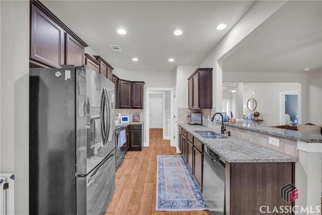 kitchen with dark brown cabinetry, light wood finished floors, visible vents, appliances with stainless steel finishes, and a sink