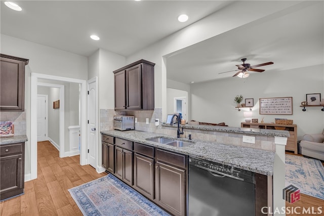 kitchen with light wood-style flooring, dark brown cabinetry, a sink, open floor plan, and dishwasher