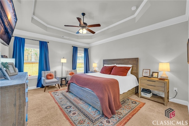 bedroom with a tray ceiling, multiple windows, crown molding, and baseboards