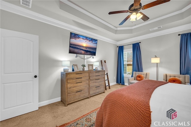 carpeted bedroom with baseboards, visible vents, a raised ceiling, and crown molding