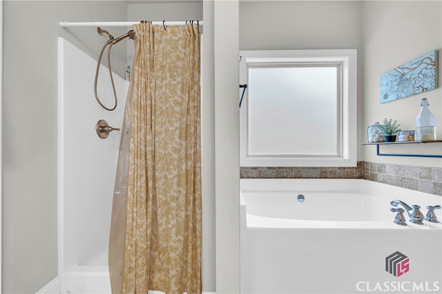 bathroom featuring a stall shower and a bath