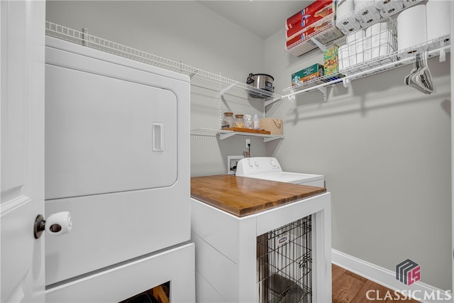 laundry room featuring laundry area, washer / clothes dryer, baseboards, and wood finished floors