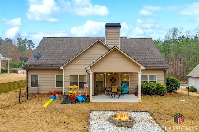 rear view of house featuring a patio, an outdoor fire pit, a shingled roof, and a fenced backyard