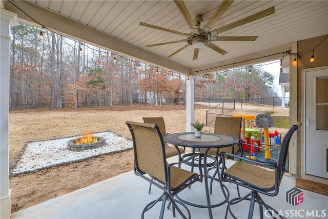 view of patio featuring an outdoor fire pit, fence, ceiling fan, and outdoor dining space