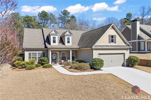 view of front of house featuring a garage, concrete driveway, a shingled roof, and a front yard