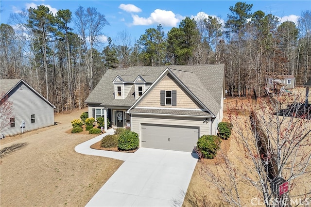 view of front of property featuring a shingled roof and concrete driveway