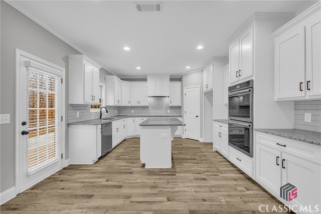 kitchen with white cabinetry, light stone counters, and stainless steel appliances