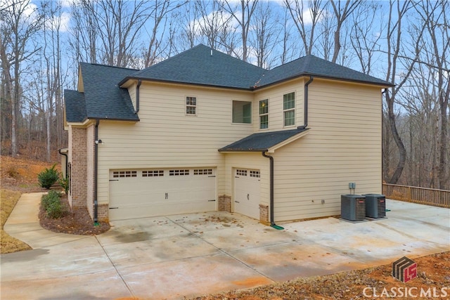 exterior space with central AC and a garage