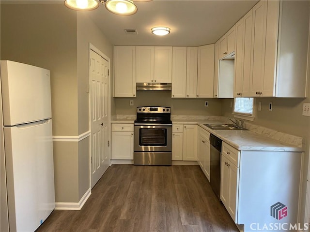 kitchen featuring appliances with stainless steel finishes, light stone counters, sink, dark hardwood / wood-style floors, and white cabinetry