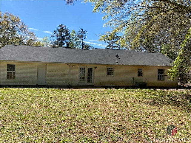 back of property with a yard and french doors