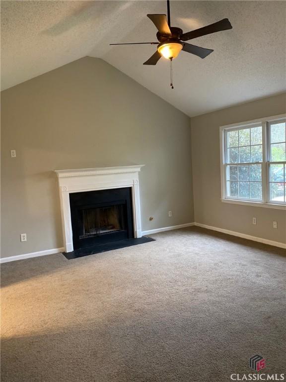 unfurnished living room with a textured ceiling, ceiling fan, carpet floors, and lofted ceiling