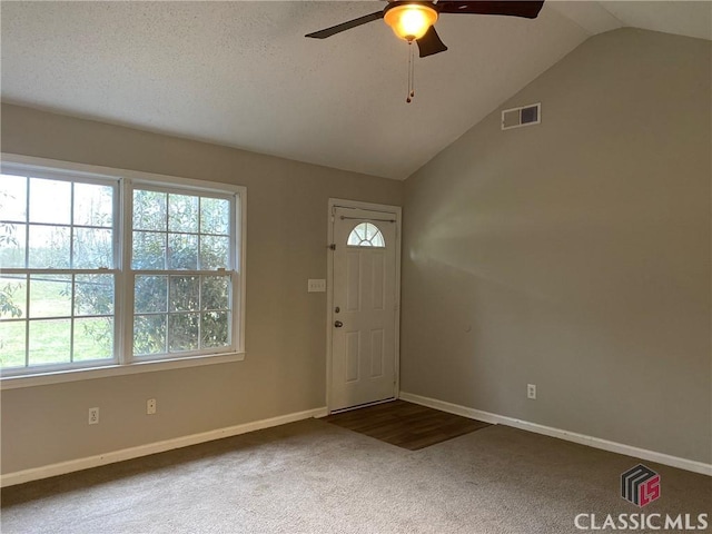 carpeted foyer with ceiling fan and lofted ceiling